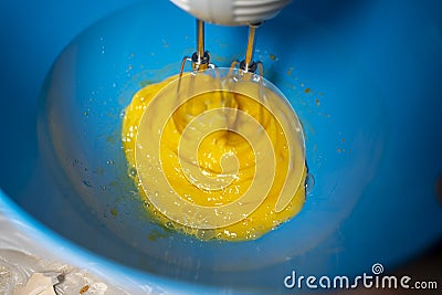 Whipping eggs with a hand mixer. Close-up Stock Photo
