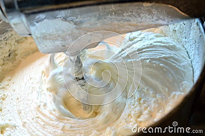Whipping homemade vanilla icing in stainless steel stand mixer Stock Photo