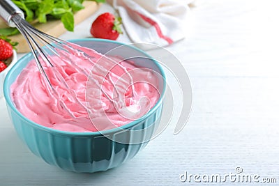 Whipping strawberry cream with balloon whisk on white wooden table, closeup. Space for text Stock Photo