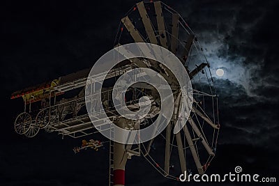 A whirligig spins in front of a full moon Editorial Stock Photo