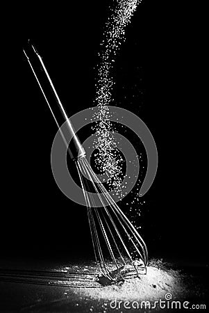 A whisk with falling flour Stock Photo