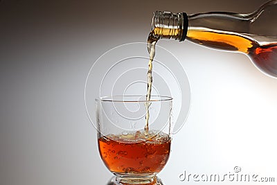 Whiskey alcohol being poured into a glass Stock Photo