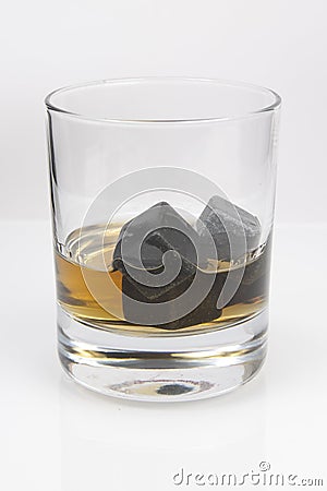 Whiskey cooling stone cubes and glass with whiskey Stock Photo