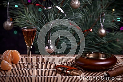 Whiskey glass, ashtray and cigar on the Christmas table. Stock Photo