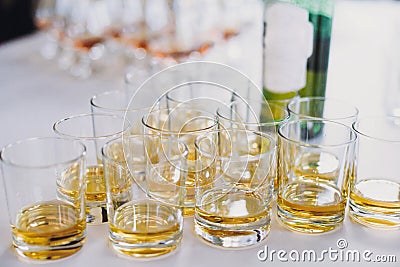 Whiskey row on table party at wedding reception. Whisky in glasses at alcohol bar. Christmas and New Year feast. Celebrations and Stock Photo