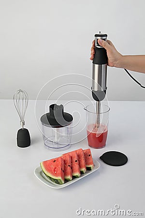 Whisking watermelon in a bowl with immersion hand blender Stock Photo
