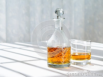 Whisky decanter and rocks glass by the window Stock Photo