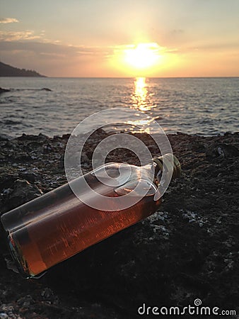 Whisky in flat Bottles on rock beach Stock Photo