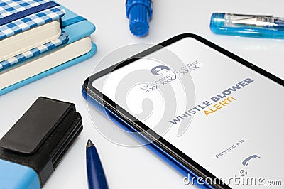 Whistleblowing concept: smartphone on white table show a whistle blower alert on an anonymous ID call Stock Photo