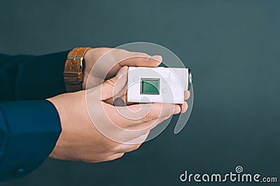 White action video camera, in the hands of a guy on a black background in the studio Stock Photo