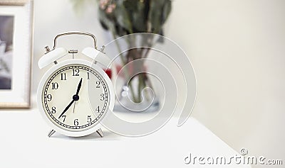 White alarm clock on bedside table. Close up Stock Photo