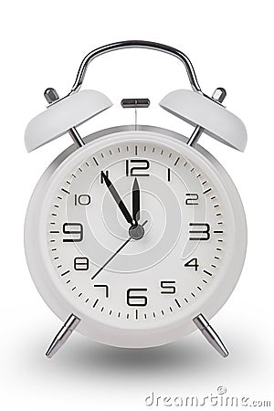 White alarm clock with hands at 5 minutes till 12 Stock Photo