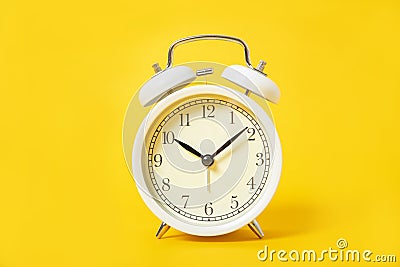 White alarm clock on a yellow background Stock Photo