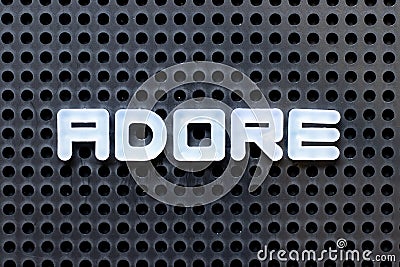 White alphabet with word adore on black pegboard background Stock Photo
