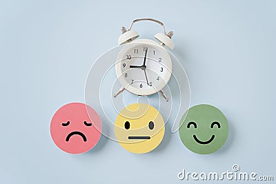 White analog clock and emotion face on blue background, satisfaction survey ,good feedback rating and positive customer review Stock Photo