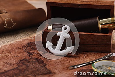Anchor near open wooden box with telescope on world map Stock Photo