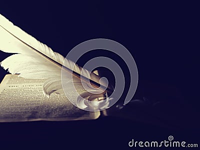 White angelic feather rests on the Bible holy book Stock Photo