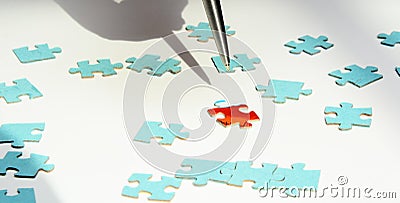 On a white background blue puzzles. A silver puzzle points to a red puzzle Stock Photo