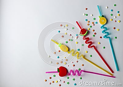 On a white background are colored twisted cocktail tubes with plastic berries Stock Photo