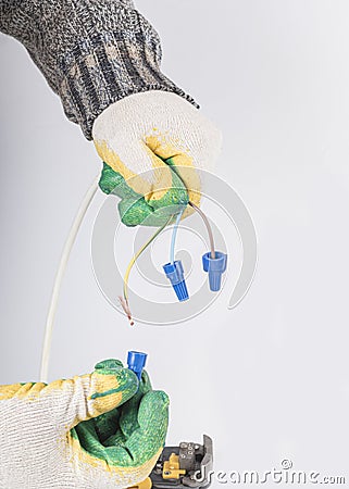 white background. electrical wires. the master removes the insulation with the help of a tool. close-up Stock Photo