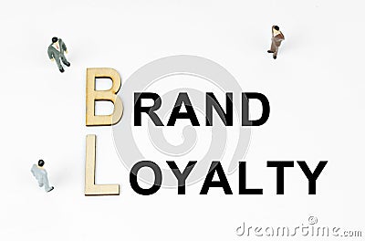 On a white background, figures of businessmen, wooden letters and the inscription - BRAND LOYALTY Stock Photo