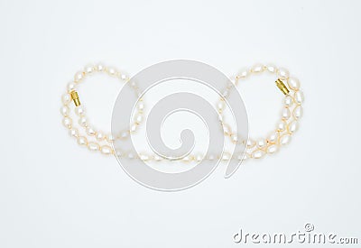 On a white background lies a pink pearl necklace on the neck Stock Photo