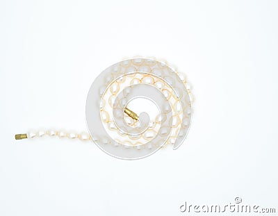 On a white background lies a pink pearl necklace on the neck Stock Photo