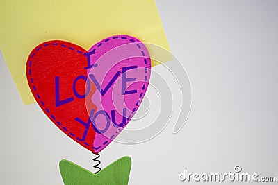 White background. Wooden heart with a clothespeg for stickers on a spring. Congratulation. Yellow paper. Stock Photo