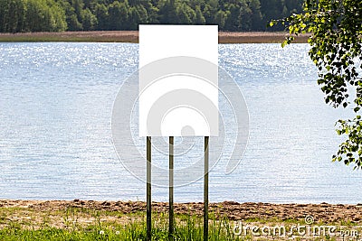 A white banner stands on the lake shore with a mockup Stock Photo