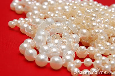 White beads on a red background Stock Photo