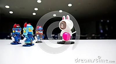 A white bear with a pink candy on a dark theater stage with no one tells the robot guards wearing blue helmets to go down. Editorial Stock Photo