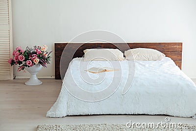 White bedroom bright interiors with bed and flowers Stock Photo