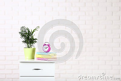 Bedside table with books, alarm clock Stock Photo