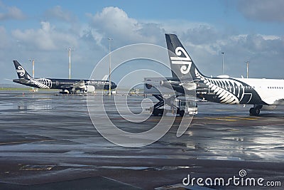 White and black Air New zealand planes parked on tarmac. at Auckland Airport after rain Editorial Stock Photo