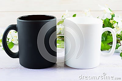 White and black mug mockup with apple blossom Stock Photo