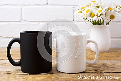 White and black mug mockup with chamomile bouquet in rustic vase Stock Photo