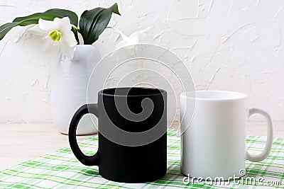 White and black mug mockup with lily in vase Stock Photo