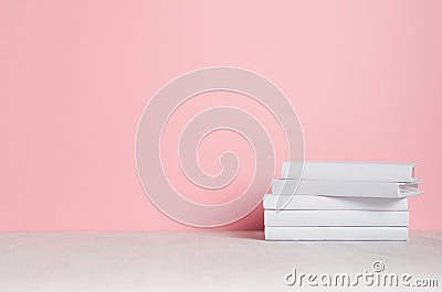 White blank books on white shelf and soft pink wall as modern, elegant home decor. Stock Photo