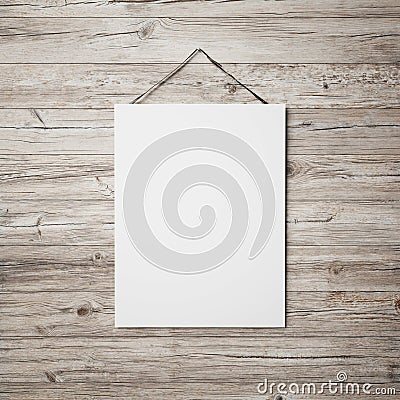 White blank poster hanging on leather belt on wood background Stock Photo