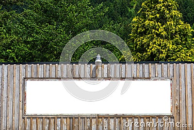 White blank rusty billboard or placard on a wooden wall in the nature. Store front Stock Photo