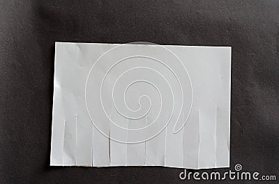 White blank sheet of paper with tear off tabs on gray background. Crumpled sheet of paper with irregular stripes Stock Photo