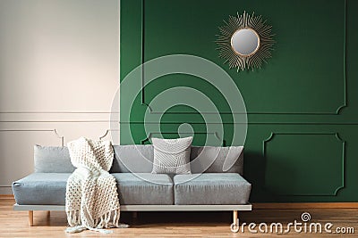 blanket and grey pillow on long comfortable couch in bright living room Stock Photo