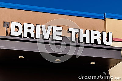 White and Blue Drive Thru sign set against a blue sky I Editorial Stock Photo