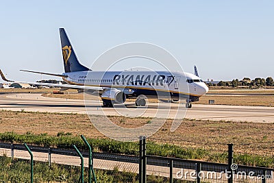 Valencia, Spain - 04 04 2023: White and blue plane with chassis is taxiing on the landscape background Editorial Stock Photo