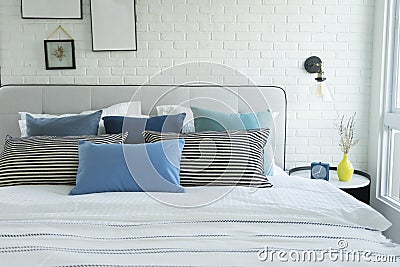 White and blue spacious bedroom with a large bed, in the Scandinavian style. Stock Photo