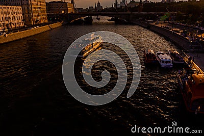 white boat sailing on the river in the sunset light. in the background a cityscape and a bridge Editorial Stock Photo