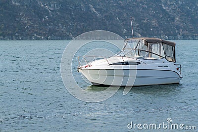 White boat in the water on the background of the hill. Stock Photo