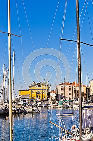 White boats, blue sky and colorful buildings at Piran harbor, Istria Stock Photo