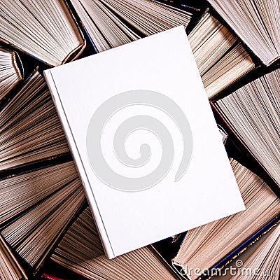 White book in white cover with a place for text lies on multicolored old open books Stock Photo