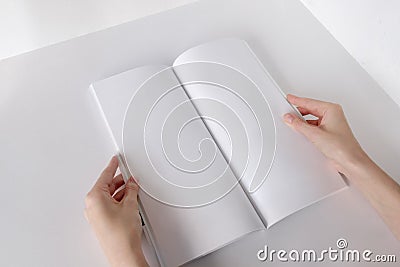 White booklet mockup. Vertical format blank booklet. A woman holds an album with blank pages. Blank cover mocku Stock Photo